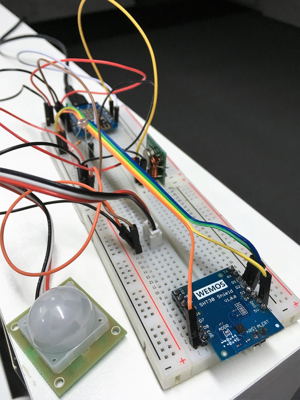 Vlevo pohybové čidlo, vpravo teploměr a vlhkoměr, uprostřed rádio a fotorezistor, vzadu ESP8266.